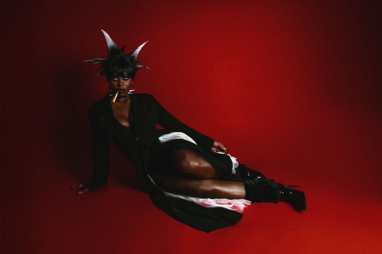 Mastering the First Impression: Your intriguing post title goes here Striking fashion portrait featuring unique hairstyle against a vibrant red backdrop.